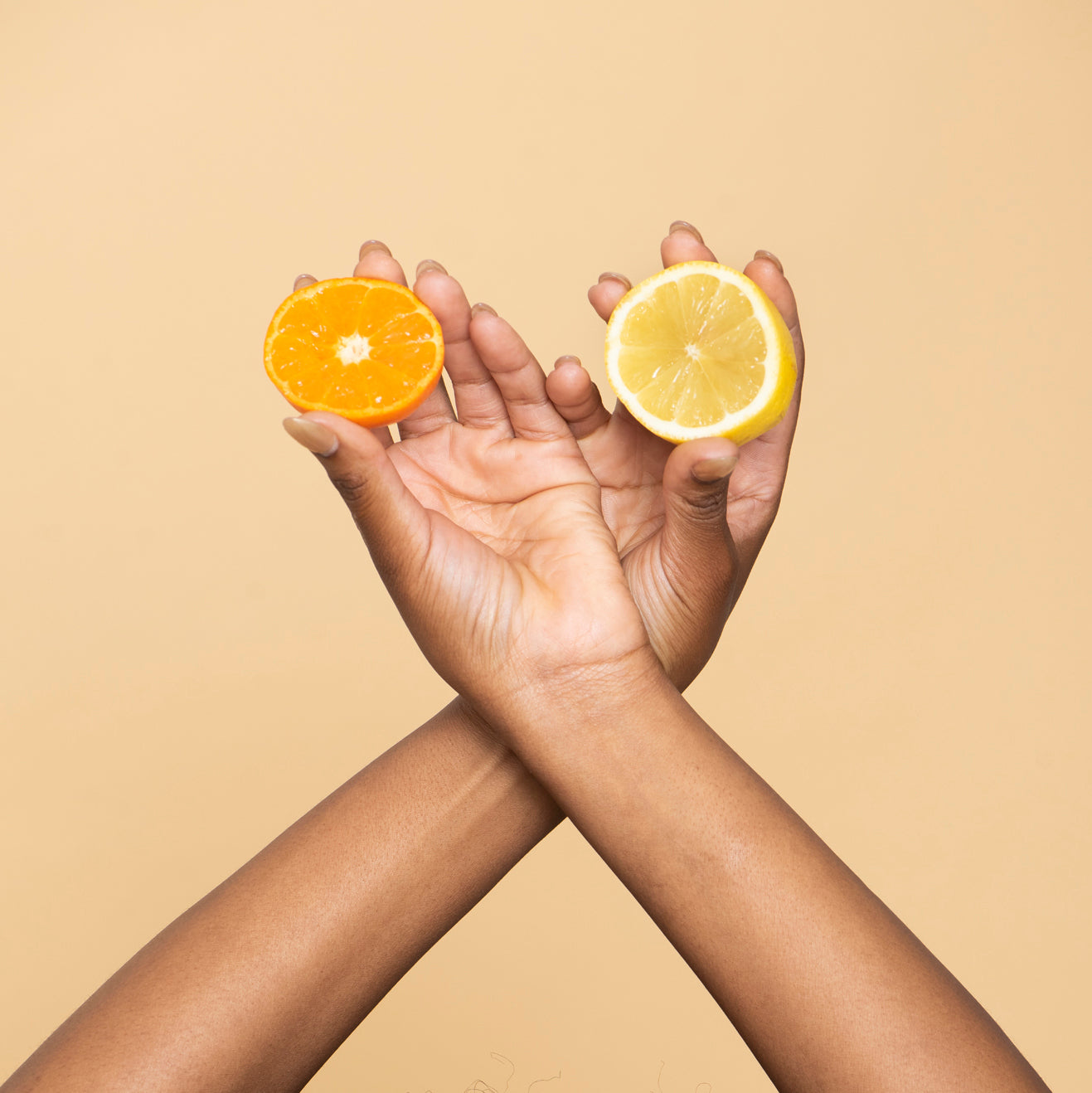Händer håller citrusfrukter som apelsin och citron – symboliserar LEKKER Have Fun deodorantkräm med frisk citrusdoft